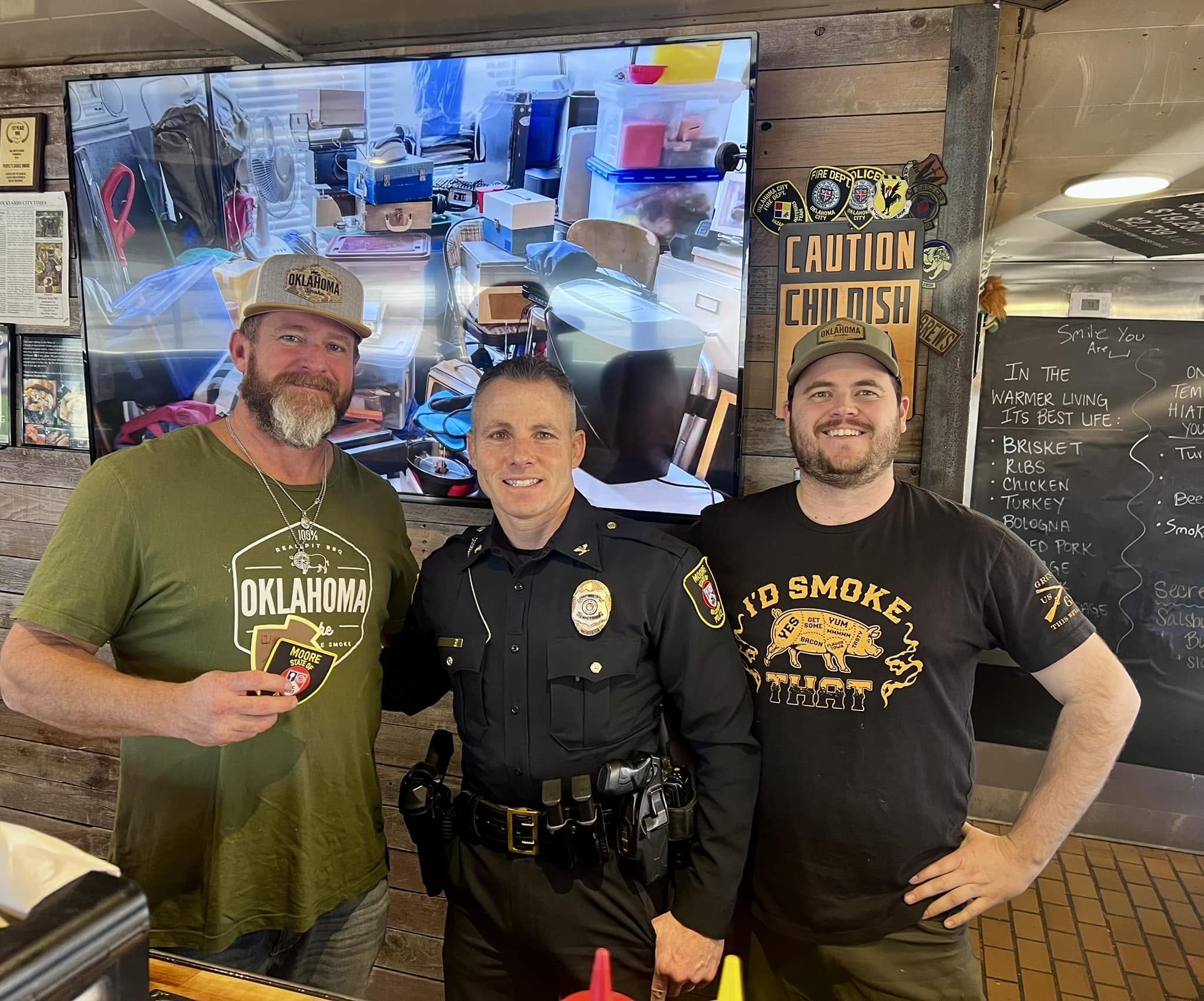 A picture of Ean and Jared taking a picture with a police officer.