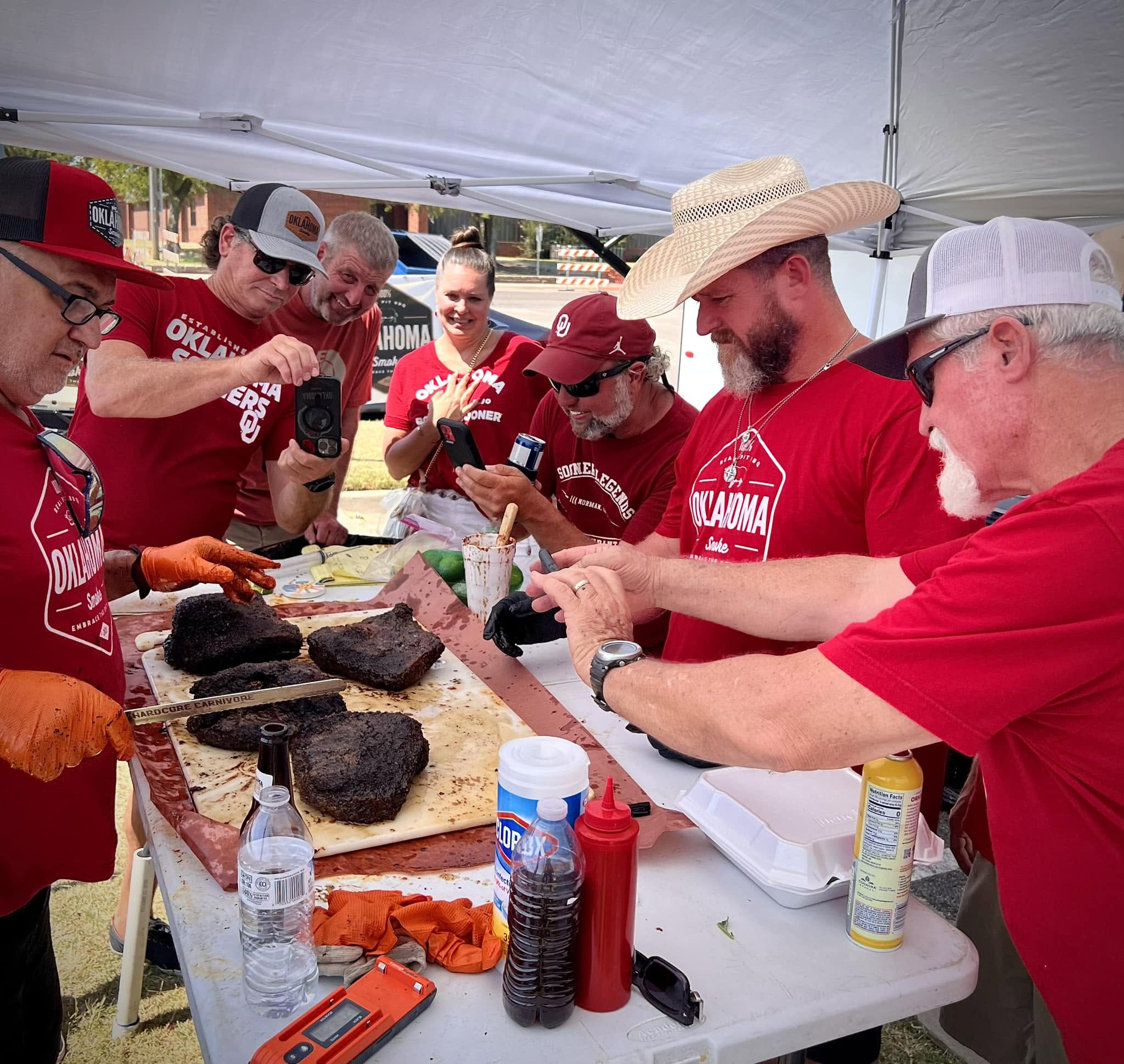 Oklahoma smoke BBQ team dressing food on a folded table all together.