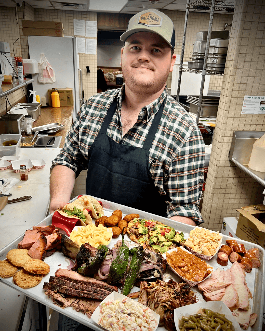 Ean Kampeyer one of the founders holding a tray of assorted food.