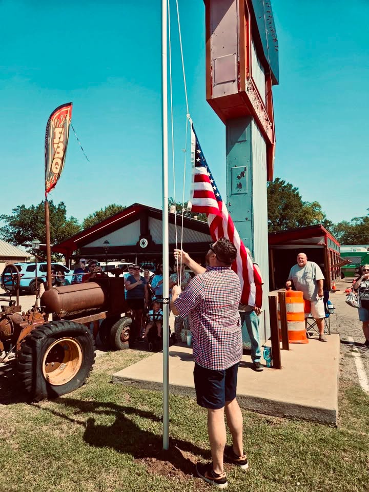 rais of the flag - Oklahoma Smoke BBQ Founder of Oklahoma Smoke BBQ putting up the American Flag Infront of the building.