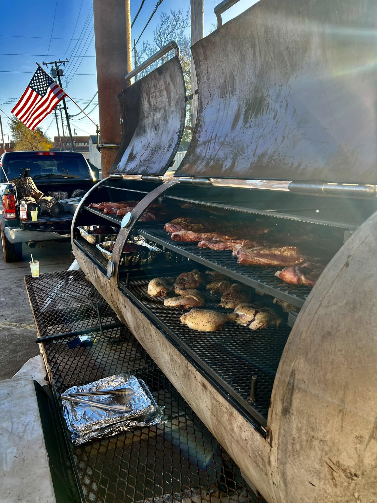 A truck pulling smokers with BBQ food smoked on them.